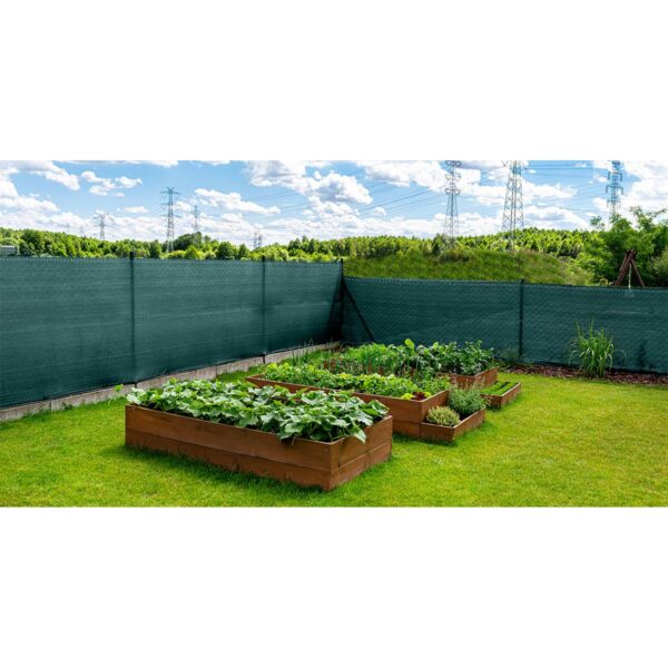 Anthracite-colored masking net placed on a mesh fence, visible vegetable boxes. Anthracite-colored masking net placed on a mesh fence, visible vegetable boxes.