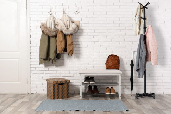 Stylish hallway interior with shoe rack and hanging clothes on b Stylish hallway interior with shoe rack and hanging clothes on b