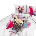 Lamp on wooden table next to a blue and white bed in bedroom int